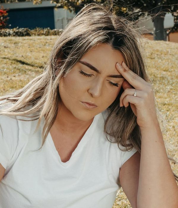 A calm woman sitting peacefully with her eyes closed, radiating a sense of well-being.